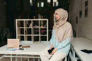 modern moslim vrouw in hijab in kantoor kamer foto