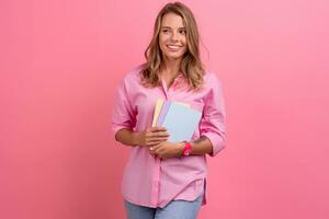 blond mooi vrouw in roze overhemd glimlachen Holding Holding notebooks foto