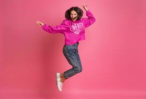 spaans mooi vrouw in roze capuchon glimlachen jumping foto