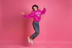 spaans mooi vrouw in roze capuchon glimlachen jumping foto