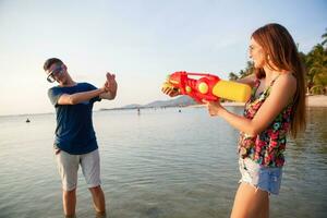 jong mooi paar in liefde spelen Aan tropisch strand foto