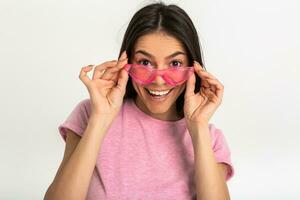 aantrekkelijk vrouw in roze t-shirt en zonnebril foto