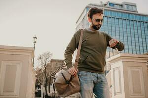 hipster Mens wandelen in straat met zak foto