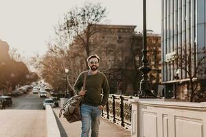 hipster Mens wandelen in straat met zak foto