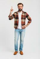 knap gebaard Mens in hipster kleding gekleed in jeans en geruit overhemd foto