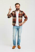 knap gebaard Mens in hipster kleding gekleed in jeans en geruit overhemd foto