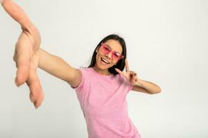 aantrekkelijk vrouw in roze t-shirt en zonnebril foto