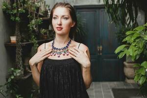 portret van jong aantrekkelijk vrouw in elegant zwart jurk vervelend luxe rijk ketting sieraden foto