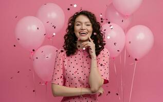 mooi jong vrouw poseren geïsoleerd Aan roze studio achtergrond met roze lucht baloons en confetti foto