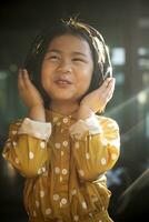 geluk gezicht van Aziatisch kinderen luisteren muziek- in hoofd telefoon foto