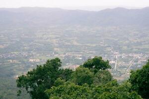 een dorp in Thailand omringd door groot groen bergen. foto