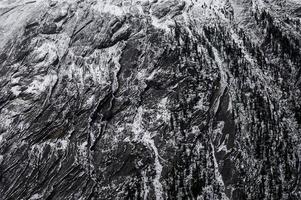 verweerde rotsachtige berg met sneeuwpatroon op textuur foto