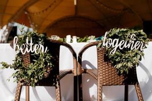 het presidium van de pasgetrouwden in de feestzaal van het restaurant is versierd met kaarsen en groene planten, de algemene toon van de zaal is beige foto