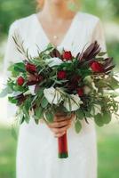 bruidsboeket van rode bloemen en groen foto