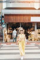 jong Aziatisch vrouw reiziger in jurk met hoed op reis naar rieten winkel Aan chang moi kao weg, toerist bezoek Bij de oud stad in chang mei, Thailand. Azië reis, vakantie en zomer vakantie concept foto