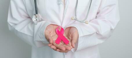 roze oktober borst kanker bewustzijn maand, dokter met roze lint in ziekenhuis voor ondersteuning mensen leven en ziekte. nationaal kanker overlevenden maand, moeder en wereld kanker dag concept foto