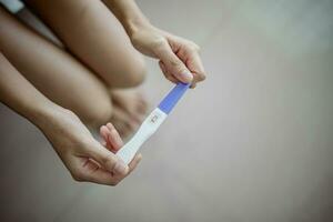 ongelukkig jong Aziatisch vrouw Holding zwangerschap test tonen een negatief resultaat. gezond en onvruchtbaarheid probleem concept . foto