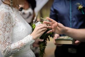 bruid zet trouwring foto