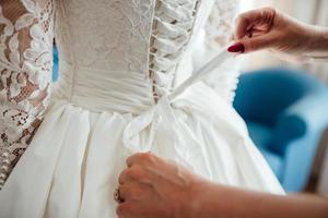 kleed de bruid aan in een trouwjurk met korset en vetersluiting