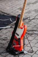rode elektrische gitaar op een standaard ligt op de grond