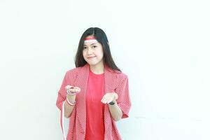 portret van mooi Aziatisch vrouw vervelend rood kleding vieren onafhankelijkheid dag met hand- gebaar presenteren iets of kopiëren ruimte foto