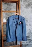 blauw blazer klassiek pak hangend aan een houten ladder foto