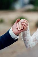 de bruid en bruidegom houden teder de handen vast tussen hen liefde en relaties