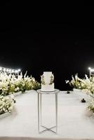 witte bruidstaart op een hoge tribune dichtbij het witte podium foto