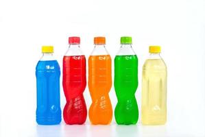 multi gekleurde dranken in plastic flessen op witte achtergrond foto