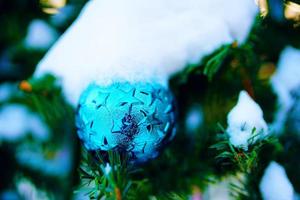 kerstversiering op bomen takken met sneeuw. foto