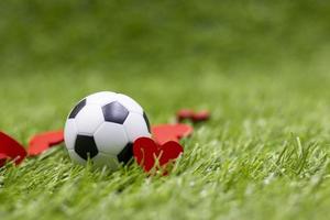 voetbal is op groen gras met liefde rood hart foto