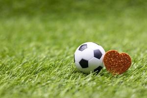 voetbal is op groen gras met liefde rood hart foto