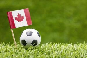 voetbal met vlag van canada op groen gras achtergrond foto