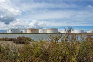 olietanks op een rij onder de blauwe lucht, grote witte industriële tank voor benzine, olieraffinaderij. energie en kracht foto