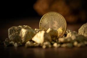 gouden bitcoin fysieke bitcoin cryptocurrency en goudklompkorrels. foto