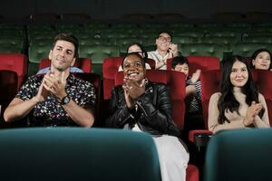 divers mensen in theater. multiraciaal publiek, zwart vrouw, en vrienden genieten aan het kijken bioscoop en applaudisseren samen Aan film shows, vermaak levensstijl met film, gelukkig en vrolijk glimlacht. foto