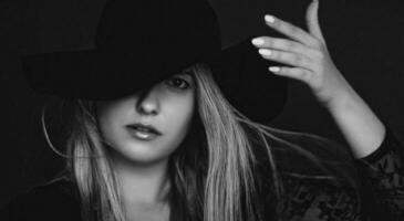 mooi blond vrouw vervelend een hoed, artistiek film portret in zwart en wit voor mode campagne en schoonheid merk foto