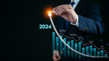 voorraad handel. financiën. investeren. groeit bedrijf. zakenman in pak richten met een pen Bij de tip van een pijl en een diagram bar vertegenwoordigt bedrijf groei in 2024. foto