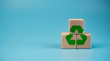 gestapeld houten blokken met groen recycle symbool. recycling concept. foto