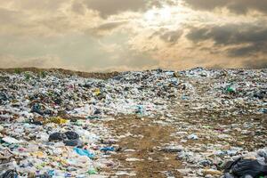 vuilnis dump stapel in uitschot dump of stortplaats, graafmachine en vrachtauto is dumping de huisvuil van gemeentelijk, afval dump stapel en donker lucht achtergrond ,vervuiling concept foto