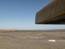 handgemaakte houten salontafel hoek op blauwe lucht en zand achtergrond foto