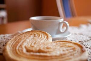 wit kop van zwart koffie en een zoet boterachtig koekje Aan de tafel foto