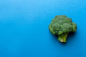 top visie vers groen broccoli groente Aan gekleurde achtergrond. broccoli kool hoofd gezond of vegetarisch voedsel concept. vlak leggen. kopiëren ruimte foto