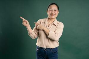 ganggang middelbare leeftijd Aziatisch vrouw portret poseren Aan blauw achtergrond foto