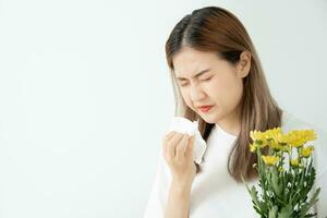 stuifmeel allergieën, Aziatisch jong vrouw niezen in een zakdoek of blazen in een veeg, allergisch naar wild voorjaar bloemen of bloesems gedurende de lente. allergisch reactie, ademhalings systeem problemen foto