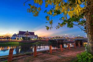 natuurlijk avond Bij visie de nan rivier- met en de naresuan brug in de park voor ontspannende wandelen jogging Bij zonsondergang in phitsanulok stad, thailand foto