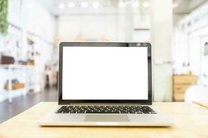 mockup beeld van laptop met blanco wit scherm Aan houten tafel van in de koffie winkel. foto