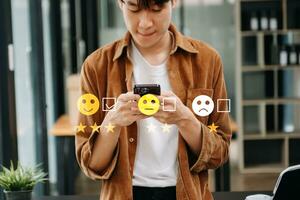 klant onderhoud evaluatie concept. zakenvrouw drukken gezicht glimlach emoticon tonen Aan virtueel scherm Bij tablet en smartphone in kantoor foto