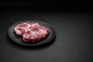 vers sappig varkensvlees steaks met zout, specerijen en kruiden foto