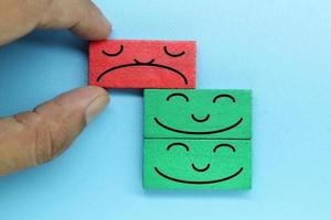 kleurrijke houten blokken met emotie gezicht. klantevaluatie en tevredenheidsconcept. foto